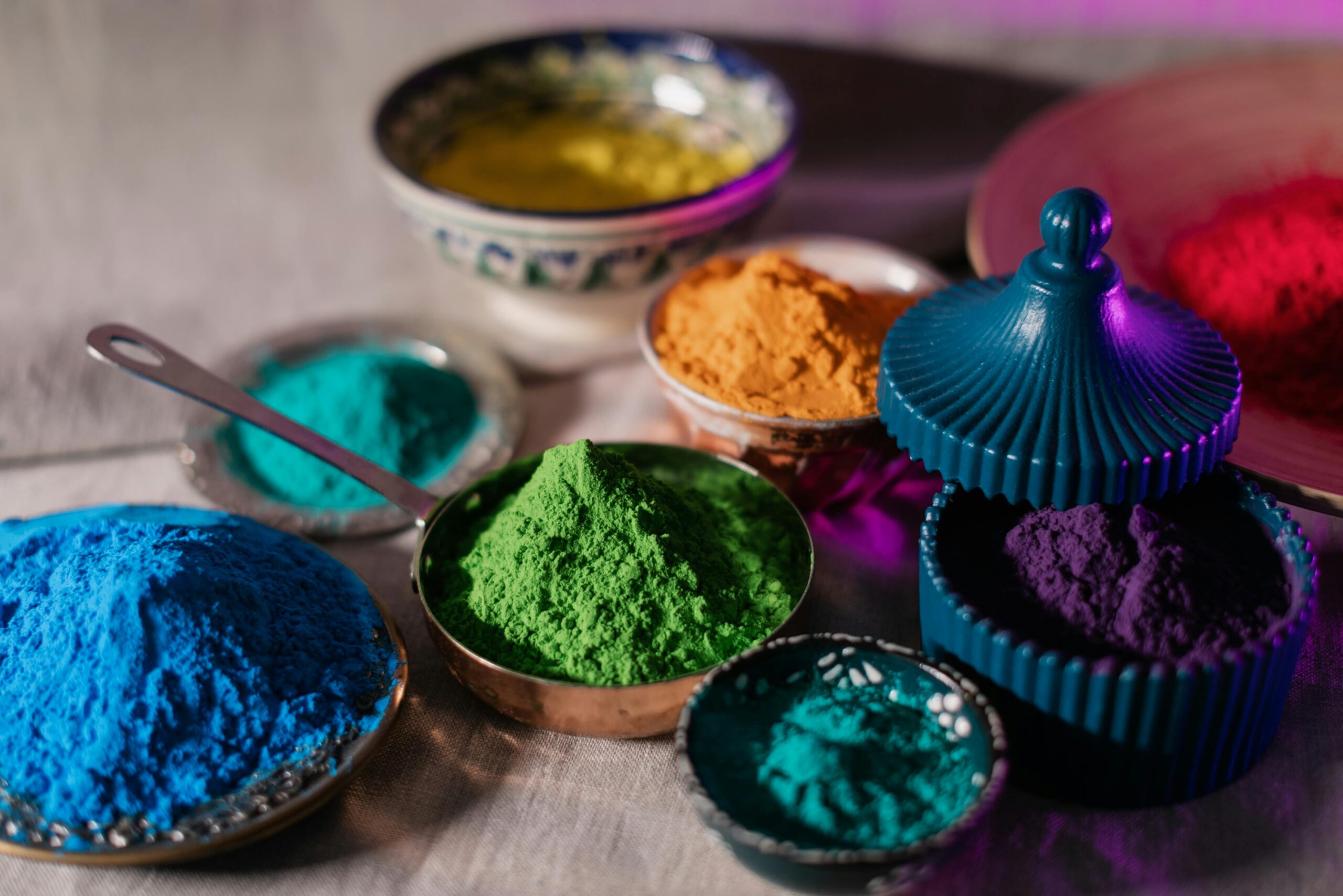 Colorful Holi powders in artistic bowls, perfect for festive celebrations and creative projects.